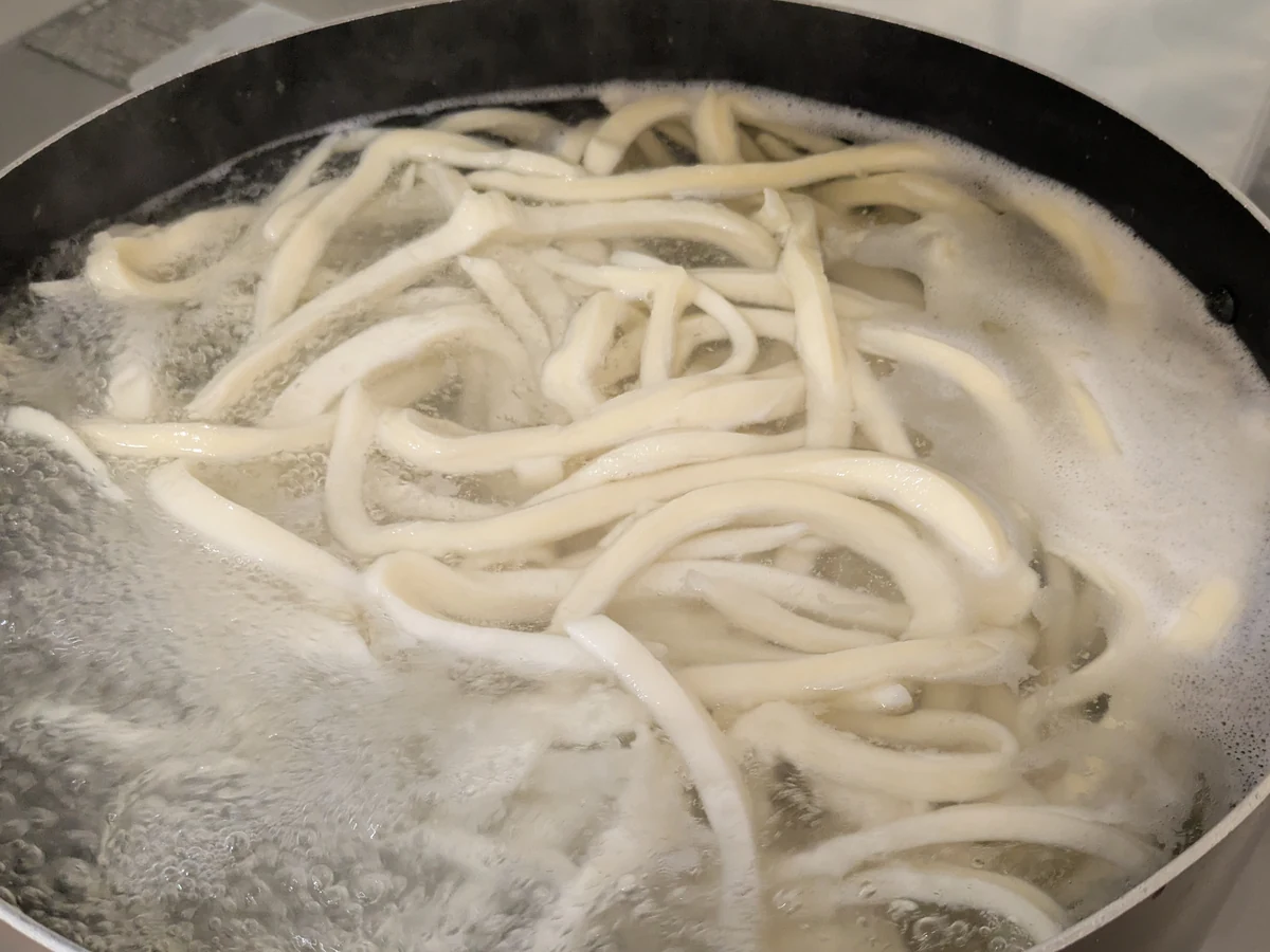 Fresh handmade udon boiling in a pot
