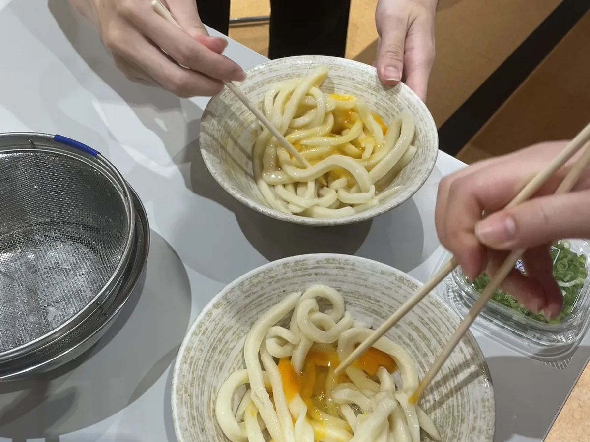 Fresh handmade udon bowls being enjoyed with chopsticks